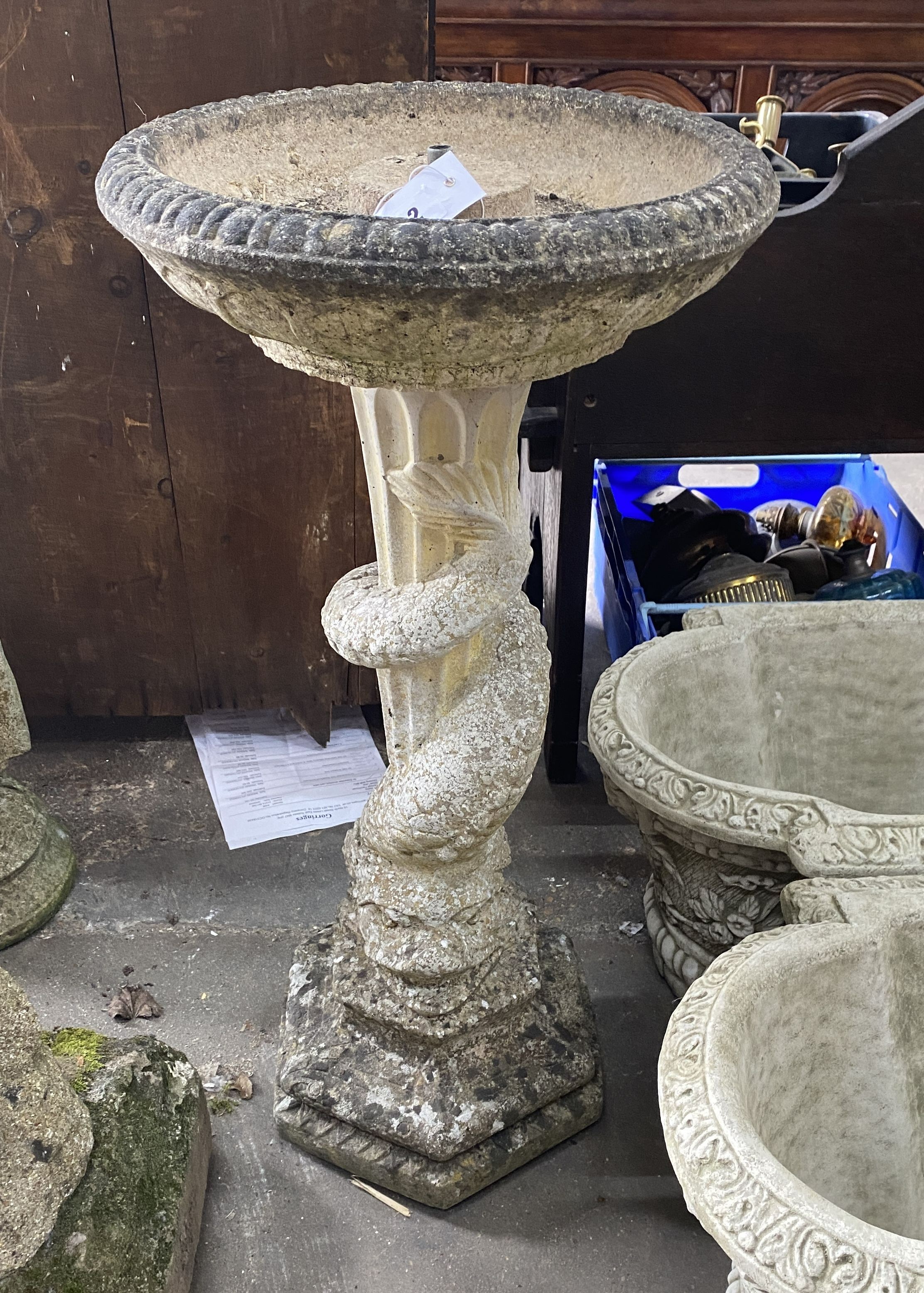 A reconstituted stone octagonal garden fountain / bird bath with dolphin stem, height 82cm